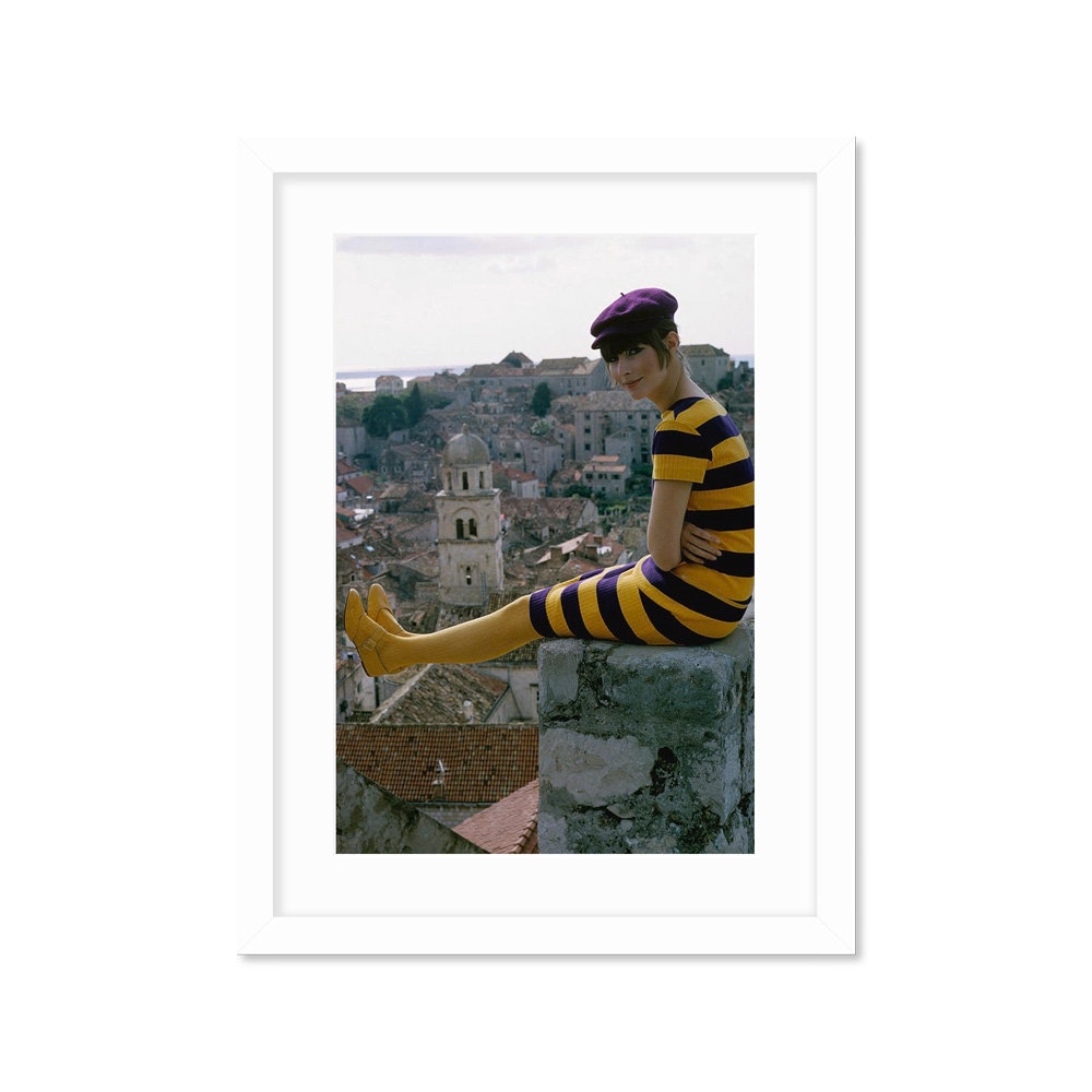 

A Woman Sitting On A Stone Wall Постер